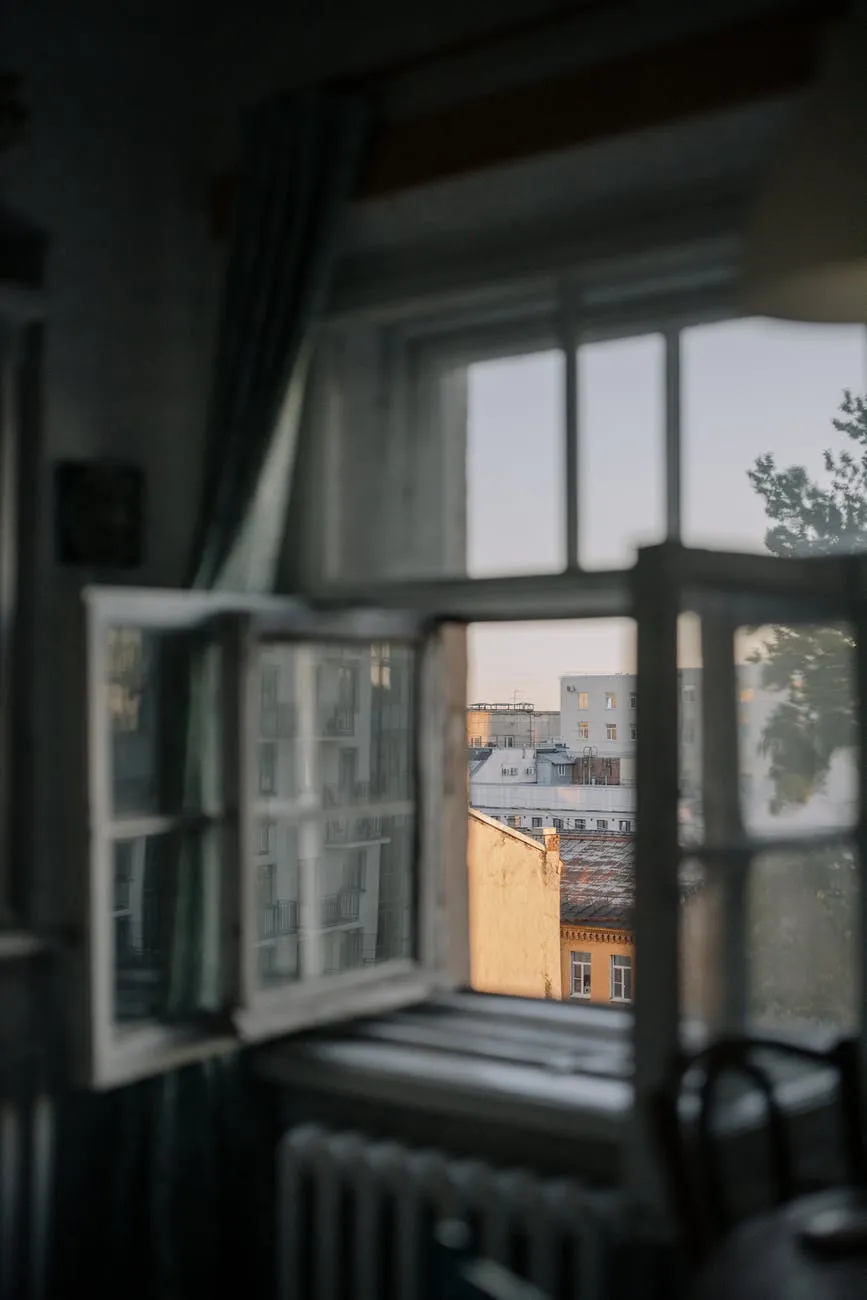 Photo looking out an open window onto a city
